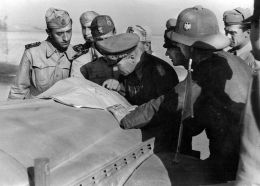 Mariscal de campo Erwin Rommel consultando un mapa sobre el capó de uno de sus vehículos.