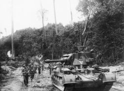Soldados de infantería del 2.º/10.º Batallón de Infantería Australiano avanzando detrás de un tanque lanzallamas Matilda Frog a lo largo de un camino en la jungla durante la Batalla de Balikpapan (Borneo, Indias Orientales Neerlandesas), el 3 de julio de 1945.