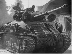 Un Sherman Mark IC Hybrid de la 5.ª División Blindada Canadiense con camuflaje en el cañón y blindaje improvisado a base de cadenas.