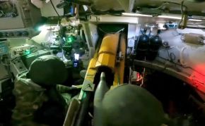 Vista desde el interior del vehículo, mientras los tripulantes recargan el arma.