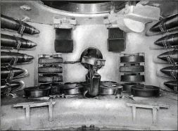 Parte trasera del interior de la torreta de un KV-1 Mod. 1941. Aquí podemos ver varios cartuchos de 76 mm sujetos con bridas a la pared y varios cargadores de munición de 7,62 mm. La ametralladora situada en la parte trasera de la torre era utilizada por el cargador. También podemos ver dos visores indirectos fijos en el techo.